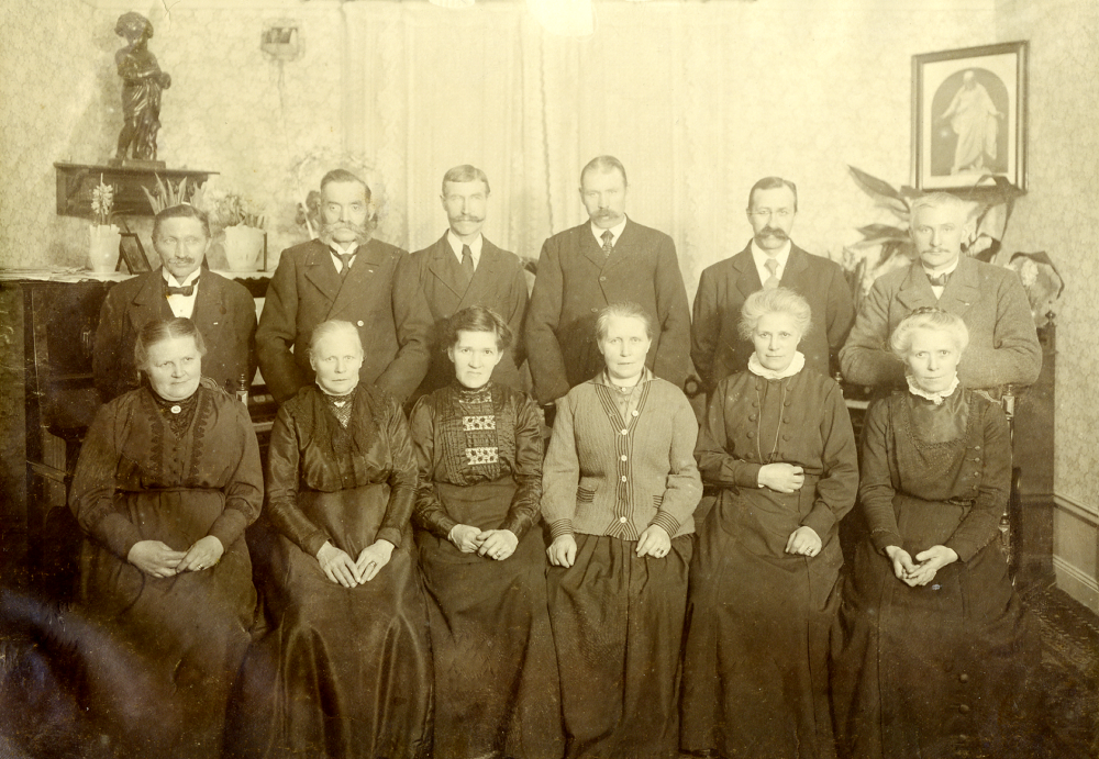 Syster- och svågersamling hemma hos Carl och Vendela Eriksson i Hagalund i Solna ca 1915, ev. i juletid eftersom det står bl a hyacinter på byrån.  I bakre raden står fr v Carl Eriksson gift med Vendela "Vendla", Severin Carlsson, gift med Josefina handlare från Karlberg i Frösunda, Augustsson, gift med Hildurs fostersyster Matilda?, August Karlsson gift med Ida, Robert Karlsson gift med Elin och längst t h Algot Laurell gift med Hildur från Wasa i Frösunda.  Ev är Algot Laurell fotograf?