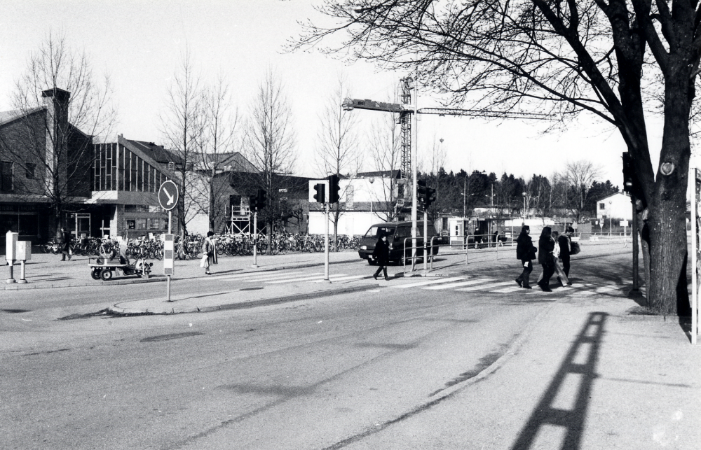 Banvägen med övergångsstället från järnvägsstationen mot Tuna torg.  I bakgrunden bygger Domus ut mot norr.  Foto från perrongen vid järnvägsstationen.