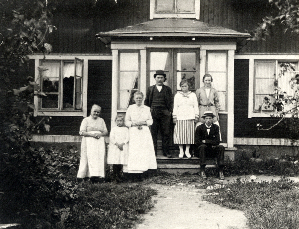 Karlberg i Frösunda.  Framför huset står fr v mormor (Ma)Tilda, Elsa, modern Tilda Karlsson, fadern skomakare Manne Karlsson, Tyra, Frida och Uno.  Manne och Tilda är föräldrar till Elsa, Tyra, Frida och Uno.  Foto förmodligen från början av 1920-talet