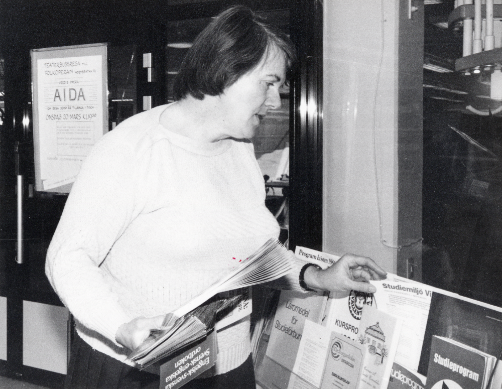 Eva Larsson  från  Vallentuna kulrukansli  städar i broschyrställen i foajén i  Vallentuna bibliotek