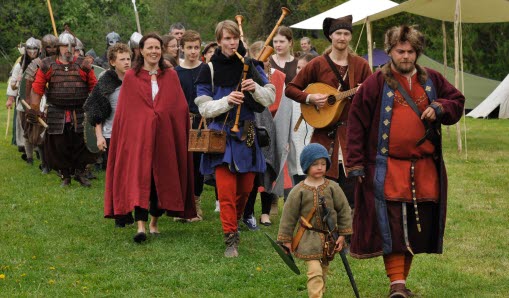 Människor går utklädda i vikingakläder i parad på Runrikets dag.