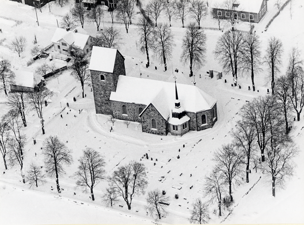 Flygfoto över Vallentuna kyrka. I bakgrunden syns Klockargården. T v om kyrkan ligger gravkapellet och pastorsexpeditonen, tidigare skola och kommunalhus