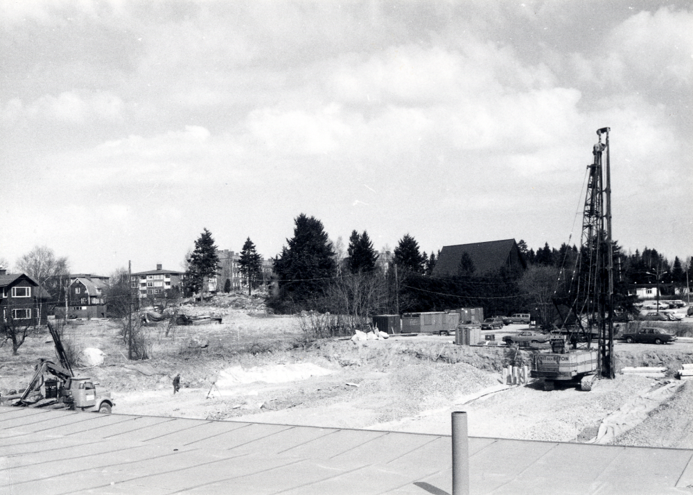 Ett nytt Domusvaruhus byggs i Vallentuna centrum norr om Konsumhuset.  Efter schaktningsarbeten för det blivande Domusgaraget  täcks marken av ett lager makadam.  Pålningsarbeten pågår för grundförstärkning, marken är gammal sjöbotten