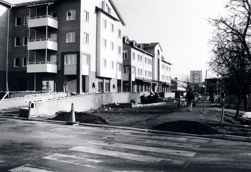 Alléhuset i Vallentuna centrum.  Gammal bebyggelse i hörnet av Allévägen och Mörbyvägen har rivits och ersatts av Alléhuset med bostäder, företag och affärer.  Allévägen har blivit gågata mot centrum. T h skymtar Kommunalhusparken