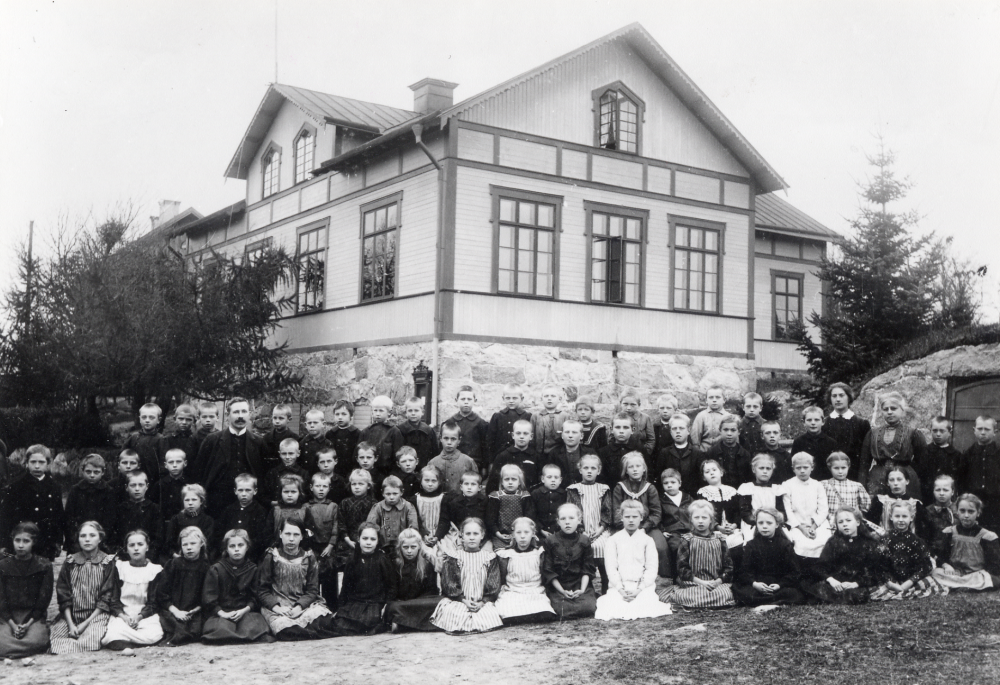 Lärarna fr v Bernhard Wiberg, Nanny Skoglund och Mathilda Linde tillsammans med skolbarnen utanför Össeby-Garns skola