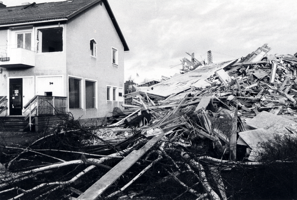 Allévägen 4 rivs för att lämna plats för ett nytt affärs- och bostadshus. T v syns Handelsbankens lokal, där banken tillfälligt flyttat ut till en barack på Gärdesvägen i avvaktan på nya lokaler i det nya huset, Alléhuset