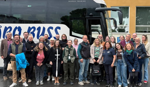 En gruppbild framför en vit buss.