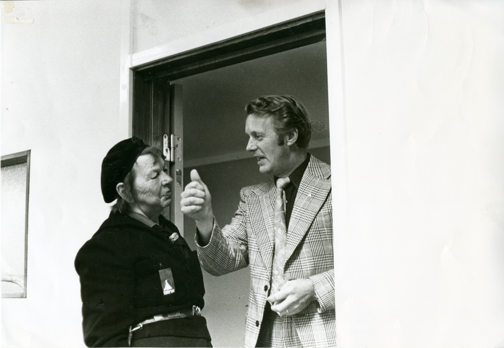 Centerpartisten Karl-Gustav Jonsson från Oppgården gör tummen upp framför Anna-Brita Dahl, Folkpartiet, dagen före valet. Centerpartiet och Folkpartiet delade lokaler på Allévägen.
•Fotografiet ingår i bildserien ”Vardagsliv i Vallentuna kommun” av Rachael Gough-Azmier & Gunilla Blomé, Haga Studios HB.