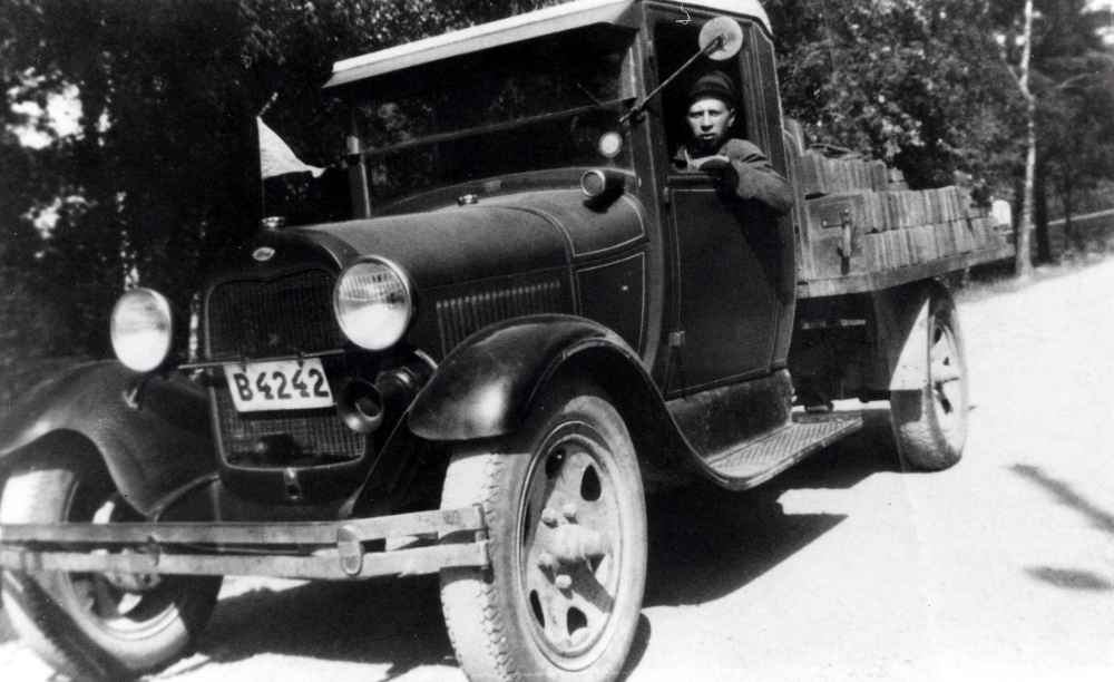 Bertil Söderbergs åkeri, Vallentuna. Här sitter han vid ratten i en Fordlastbil sommaren 1930.  Bertils far Emil Söderberg hade skjutshåll med två hästar och gästgiveriverksamhet i huset.  Men sonen Bertil tyckte det var dags att satsa på lastbilsburna transporter.  Bertil Söderberg körde från 1928  tegelprodukter från  Åby tegelbruk, men senare även från Vallentuna tegelbruk,  till olika byggen i Stockholmstrakten och i Vallentuna.  T ex körde han allt tegel till bygget  av husen längs Centralvägen.  Bertil Söderberg levde 1909-1981