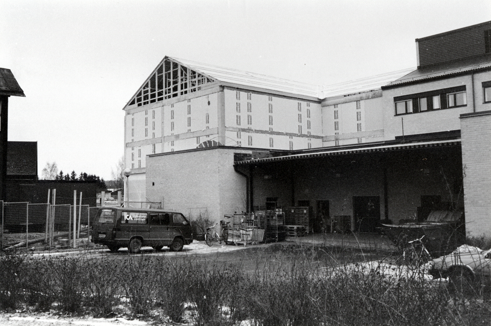 Från förvaltningshuset Tärningens baksida syns fr v gaveln på den kvarvarande Tvillingvillan, utbyggnaden av affärs- och bostadshus mellan Tärningen och Pingstkyrkan samt  Tärningens nybyggda, ännu ej färdiga fasad.  ICA Vallentuna centrum har sitt varuintag med infart från Mörbyvägen