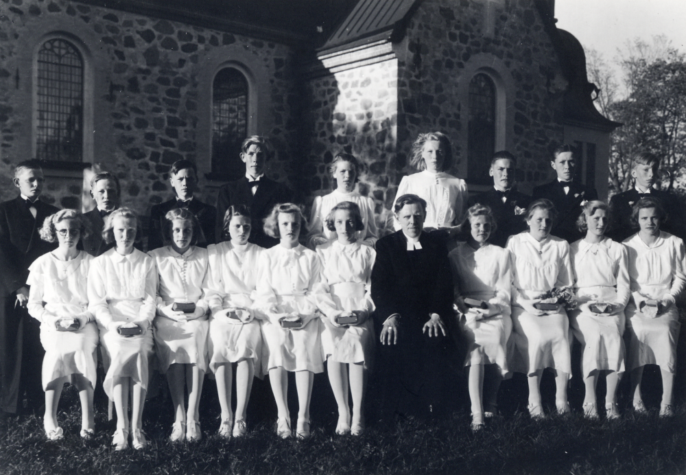 Konfirmation i Vallentuna kyrka den 30 april och 1 maj 1941. Främre raden fr v: Britta Lind, Svea Nordström, Marian Karlsson Väsby, Maj Gustavsson Björkby, Anne-Marie Malmberg, Inga Larsson, kyrkoherde Sven Vängby, Maud Andersson, Eva Skagerlind, Inga Lindersson och Margit Karlsson. Bakre raden fr v Sigvard Gustavsson, Rolf Allenius, Rolf Vallsten, Allan Lindhagen, okänd, Gunborg ???, Tage Karlsson-Curbo, Olle Andersson Olhamra och Bengt Eriksson