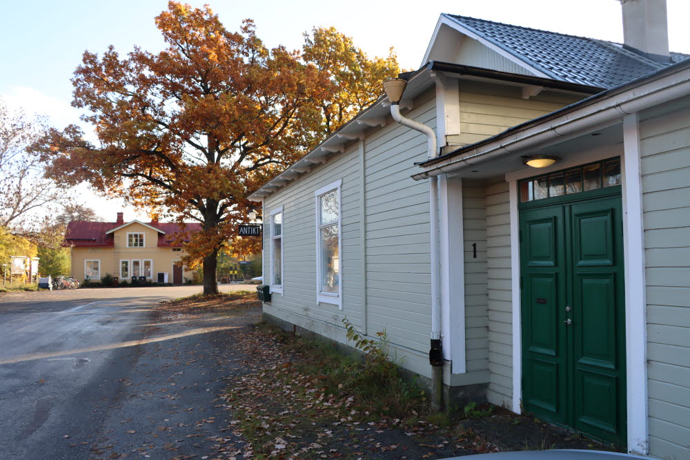 Bebyggelse i Lindholmen med antikbutik i förgrunden och stationshus i bakgrunden. 