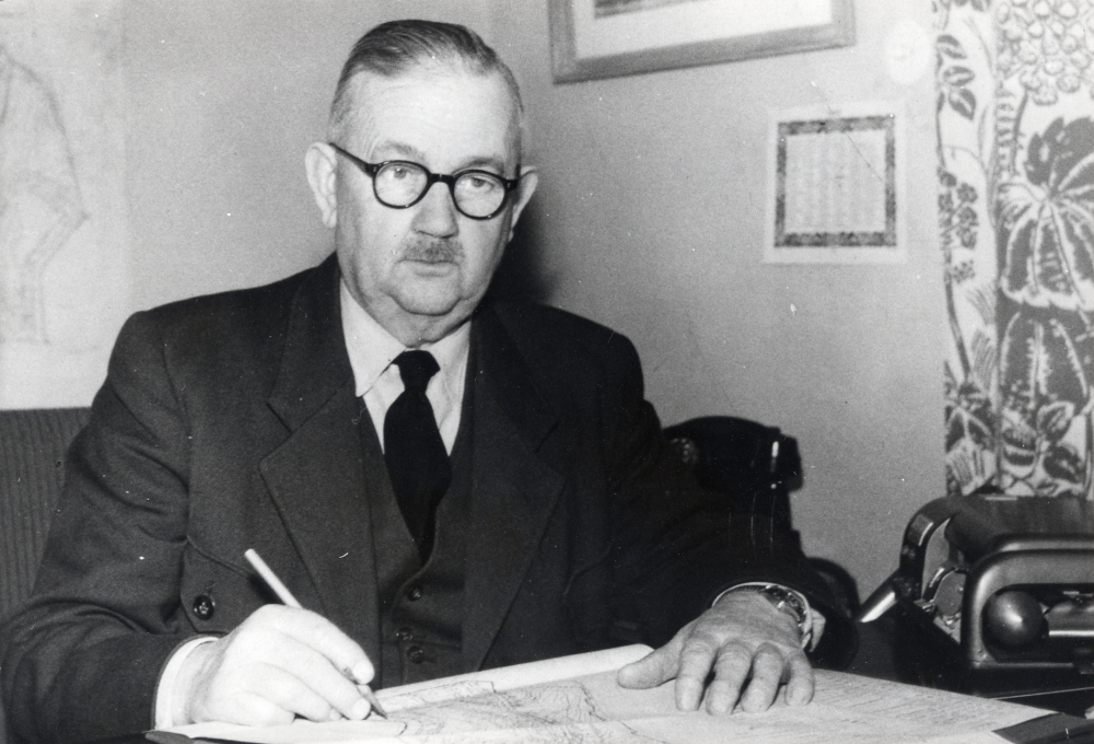 Lokförare Hugo Rosén var kommunalnämndens ordförande 1942-1951 samt suppleant i taxeringsnämnden 1938-1942 och ledamot 1943-1953.  Här sitter han vid ett skrivbord med planritningar framför sig