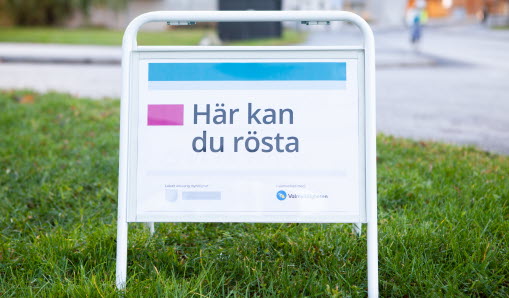 Skylt på gräsmatta med text som säger här kan du rösta.