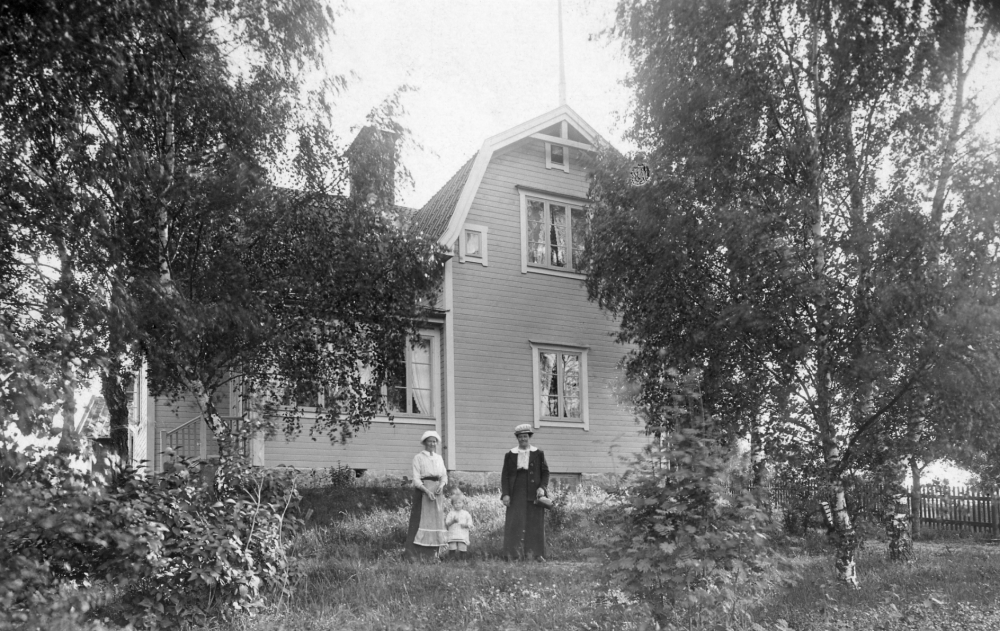 Villa Björknäs med nuvarande adress Olsborgsvägen 26.  Utanför huset står Anna Pettersson med sonen Ragnar "Ragge" samt fru Alfvén, som var sommargäst med sin familj