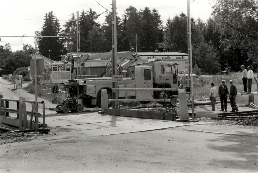 Ormsta hållplats får nytt mötesspår.  Vid övergången står en lastbil på spåret.  Med hjälp av hydraulik får lastbilen järnvägshjul.  Under tiden arbetet med mötesspåren pågick var Roslagsbanan avstängd och trafiken upprätthölls med landsvägsbuss
