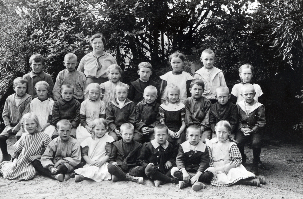 Lärarinnan Elin Englund tillsammans med barnen vid Orkesta småskola. I bakre raden fr v Nils Hammastedt, Sven Johansson, lärarinnan Elin Englund, Elsa Juhlin, Nils Lundkvist, Helny Karlsson, Erik Johansson och Helny Andersson. Mellanraden fr v Evald Johansson, Elsa Lundin, Enar Lundkvist, Edit Ström, John Karlsson, Eskil Johansson, Edit Johanson, Erik Öhman, Agne Egnell och Gösta Nordahl. Nedre raden fr v Anny Johansson, Holger Kvist, Inez Gustafson-Matsson, Elis Egnell, Sune Åman, G Olsson och Ester Lundin
