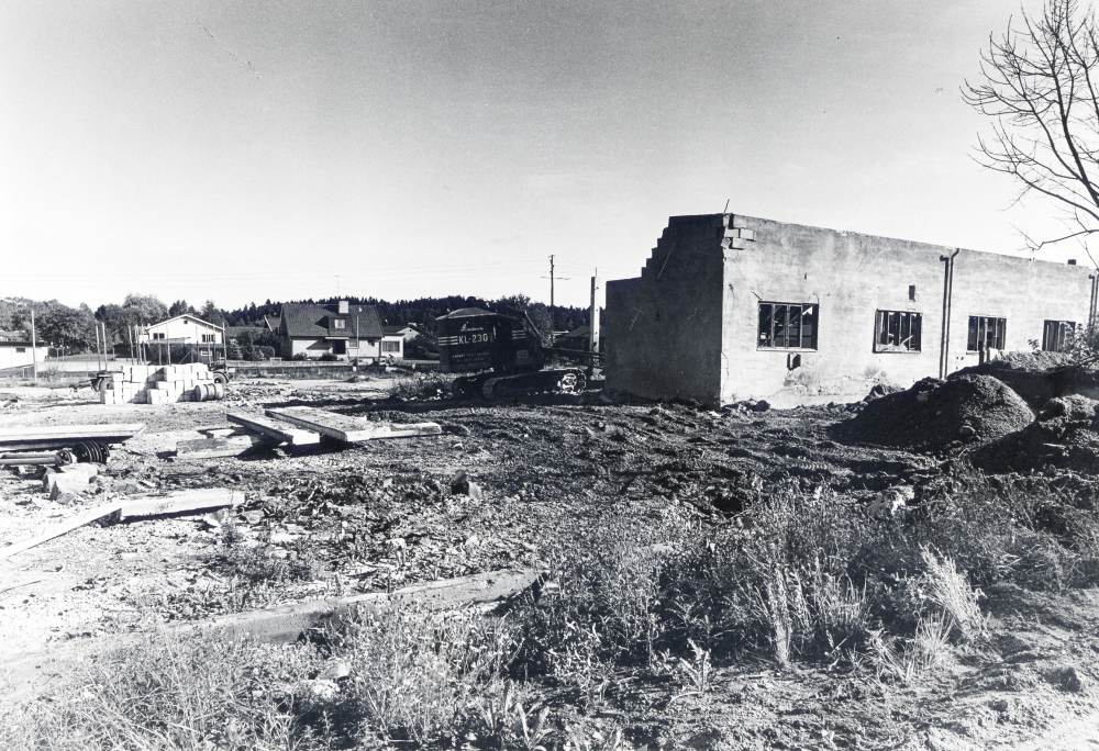 Liljeholmens cementvarufabrik i Bällsta rivs för att ge plats åt ett nytt bostadskvarter med radhus, Bällstagård I fabriken tillverkades bl a plattformskanter. Fram till 1959 fanns här en fabrik Nya aktiebolaget Santorinverken som tillverkade träullsplattor. Den fabriken brann ner 1959. Foto taget från Bällstavägen mot öster. Husen i bakgrunden har adress Artillerivägen