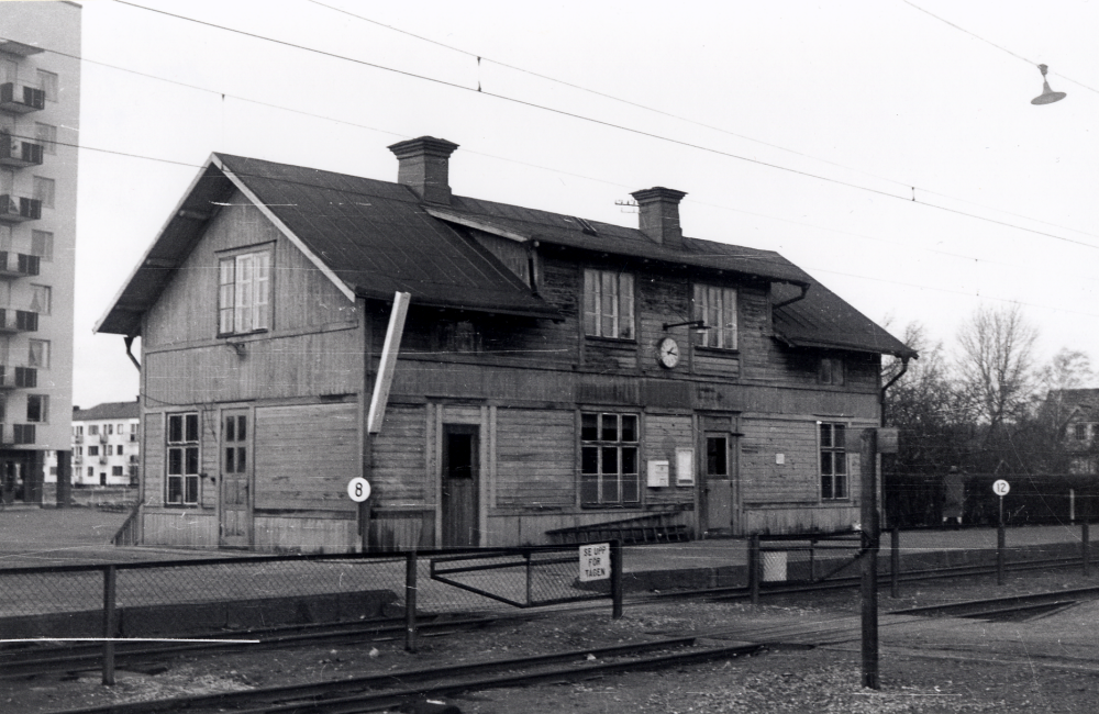 Täby järnvägsstation.  Det gamla stationshuset finns ännu kvar, men det nya huset är byggt söderut (finns inte med på bilden).  Sedan Täby centrum invigts i slutet av 1960-talet och fått egen station med namnet Täby centrum har denna station fått namnet Täby kyrkby.  I bakgrunden syns det enda "höghus" som byggdes, flera hus var planerade från början.