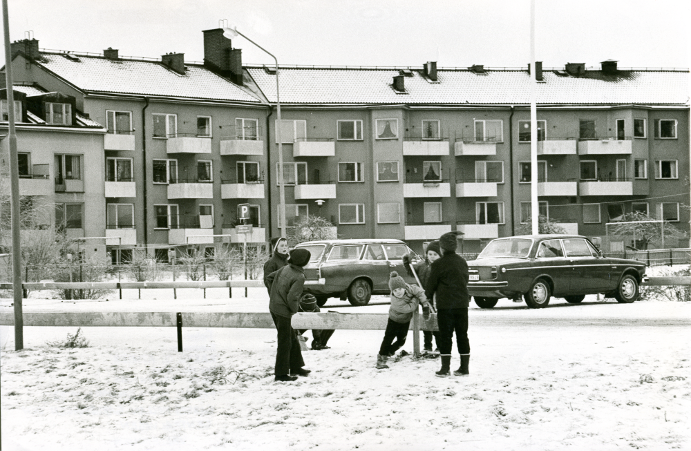 Barn leker i snön på gården, gärdet mellan Gärdesvägen och Centralvägen.

•Fotografiet ingår i bildserien ”Vardagsliv i Vallentuna kommun” av Rachael Gough-Azmier & Gunilla Blomé, Haga Studios HB.