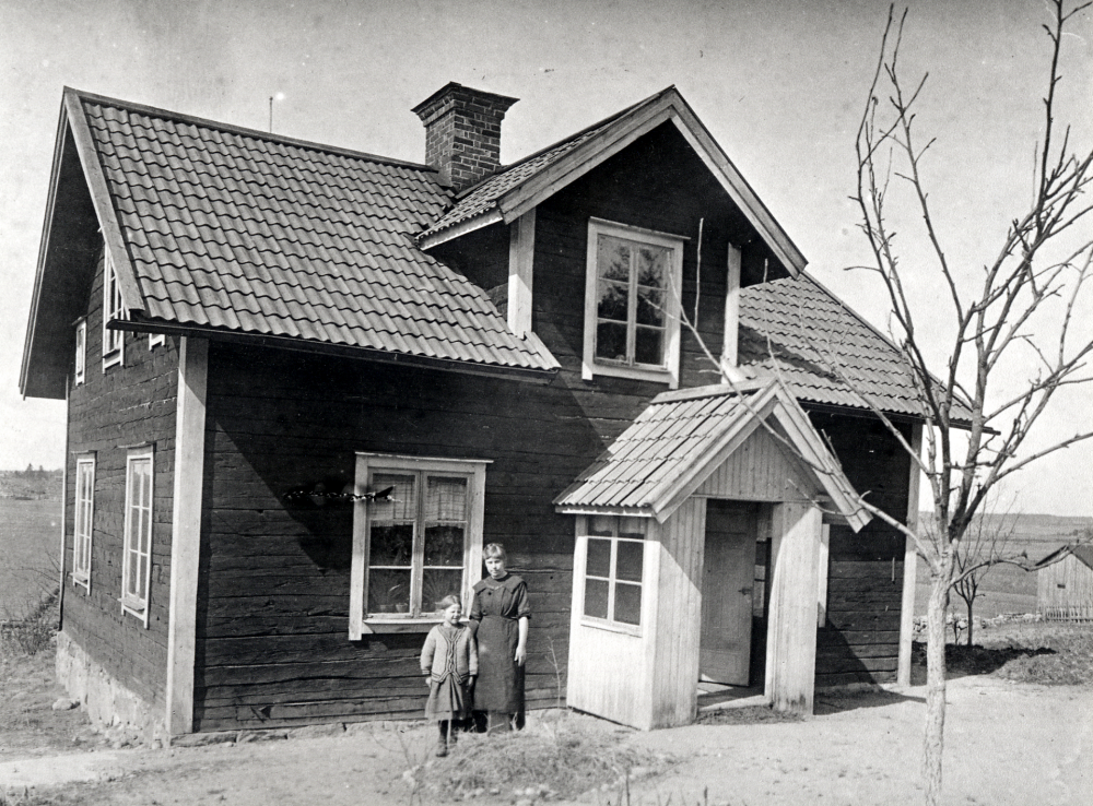 Villa Fridsborg låg i hörnet av nuv Åby gata och Lindholmsvägen.  Utanför huset står t h Hildegard Olsson, den andra flickan är okänd
