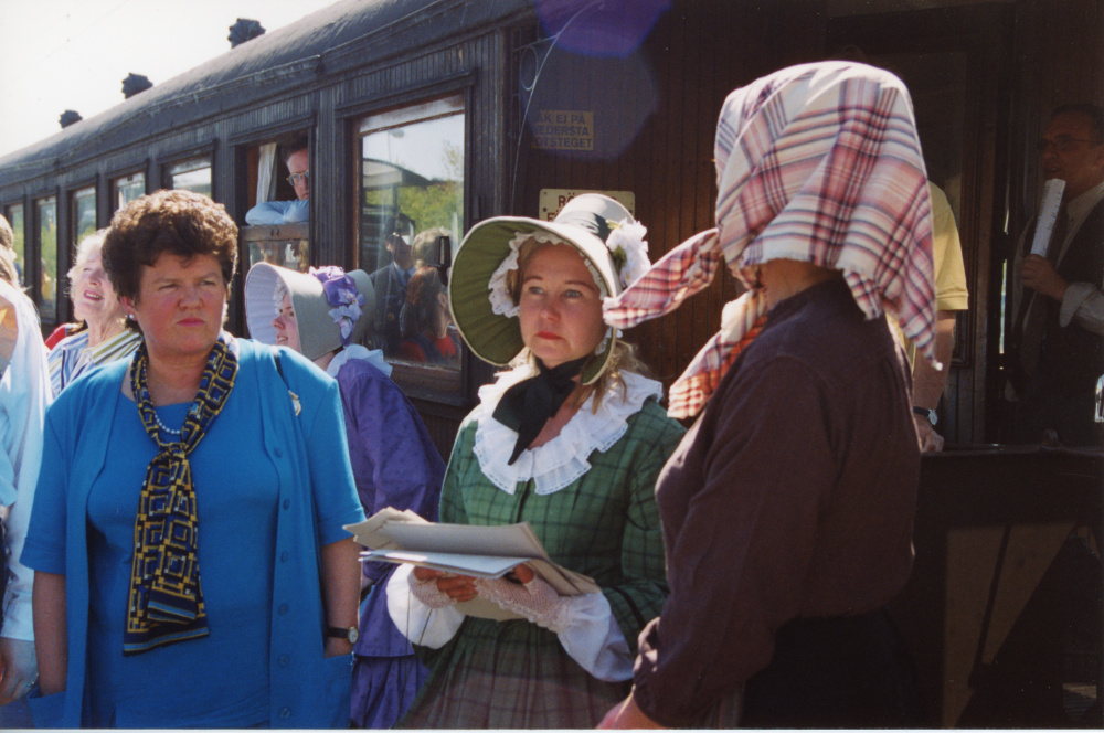 "Med tåg i kulturbygd" – ett samarbetsprojekt mellan kommunerna längs Roslagsbanan och Stockholm kulturhuvudstad 1998. Ett tåg med gamla vagnar från Roslagsbanans veterantågsförening har kört från Stockholm Östra till Vallentuna station. Från vänster kommunalrådet Birgitta Almlöf som invigningstalade, Tant Grön – Sophia Laurin som var guide på tågresan och Tvätt-Kristin –  Eva Rahmqvist som mötte upp på stationen.
