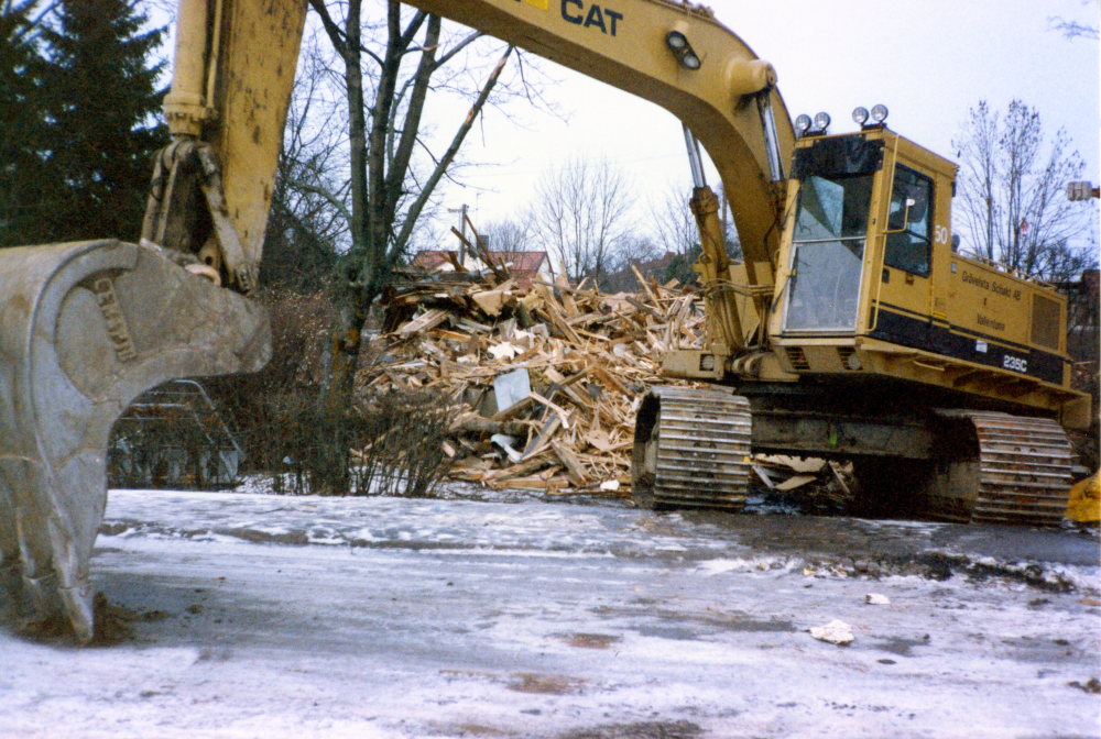 Gammal bebyggelse rivs för att ersättas med nytt. Grävskopa.