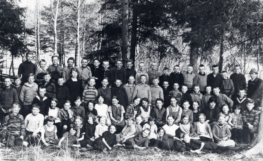 Skolbarnen och lärare vid  Markim-Orkesta skola  samlade med skogen i bakgrunden. Lärare:  Andrén  fröken  Greta Söderén  samt en vikarie