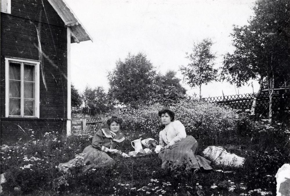 Sigrid Eriksson  och  Rut Eriksson  i gröngräset utanför  Klippan  med  förfriskningar  på en bricka