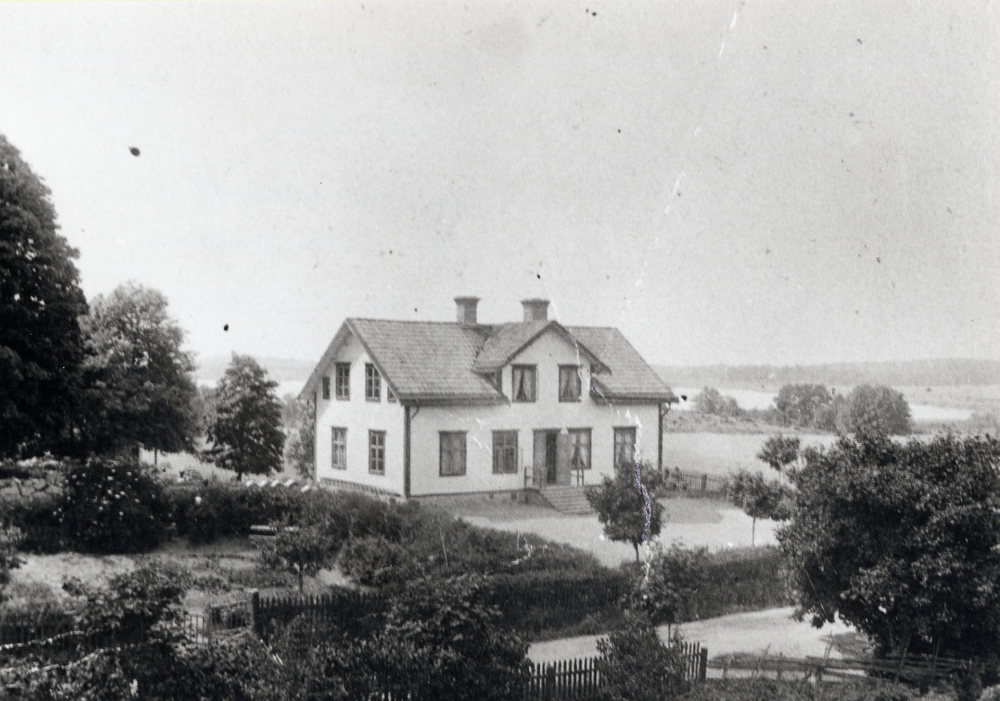 Vallentuna småskola i början av 1900-talet.  Enligt en anteckning från Aina Bornholm fanns småskola, läsbarn och lärarbostad i huset.  Inget byggår finns angivet.    T v om skolgården hade lärarinnan Hanna Krantz sin trädgård med bl a potatisland.  I bakgrunden syns Kyrkviken.  Före 1950 var huset säte för Vallentuna kommuns förvaltning.  

Se Andersson, J, Från byskola till grundskola