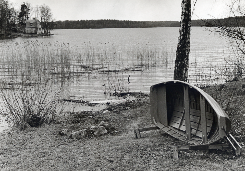 Vallentunasjön vid  Arkils tingstad  Det ljusa huset t v ligger på  Hasseludden. Vid stranden ligger en  roddbåt  upplagd