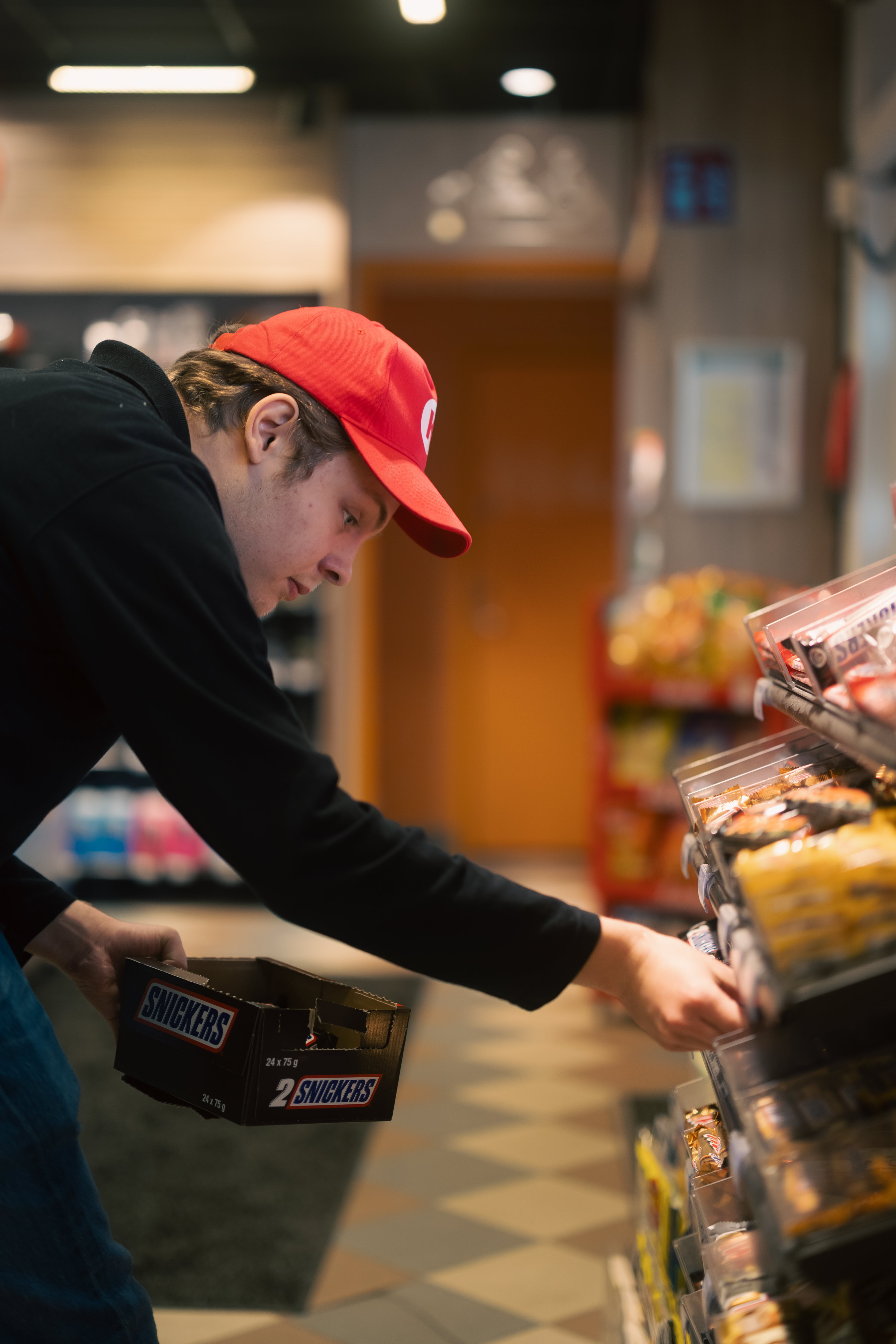 Elev fyller på med godis i hyllorna som en del i sin praktik.