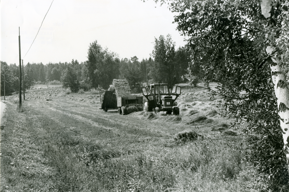 Höet bärgas med traktor och vagn. Höskörd.
•Fotografiet ingår i bildserien ”Vardagsliv i Vallentuna kommun” av Rachael Gough-Azmier & Gunilla Blomé, Haga Studios HB.