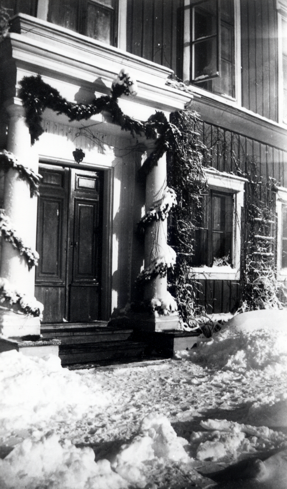 Bällsta gård.  Tallgirlanger är virade runt stolparna och över dörren vid entrén