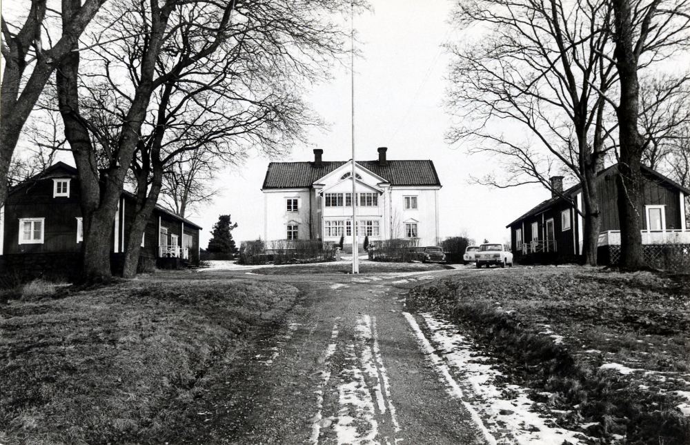 Molnby gård. På gårdplanen står tre personbilar parkerade