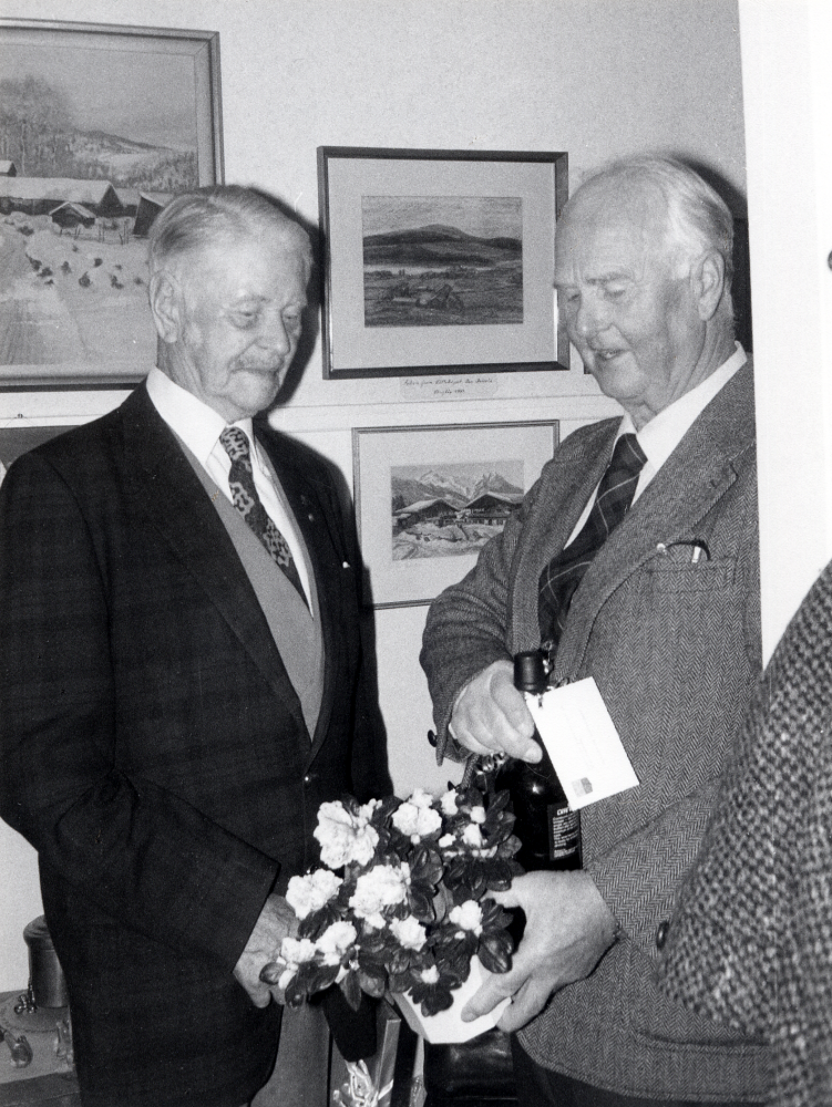 Josef Andersson  t v fyller 90 år och uppvaktas i hemmet på Skolvägen 11 av Gustaf Åkerblom med blommor och en flaska.  Gustaf Åkerblom representerar socialdemokraterna och kulturnämnden.  Josef Andersson vad en kulturpersonlighet i Vallentuna.  Han avled i januari 1992